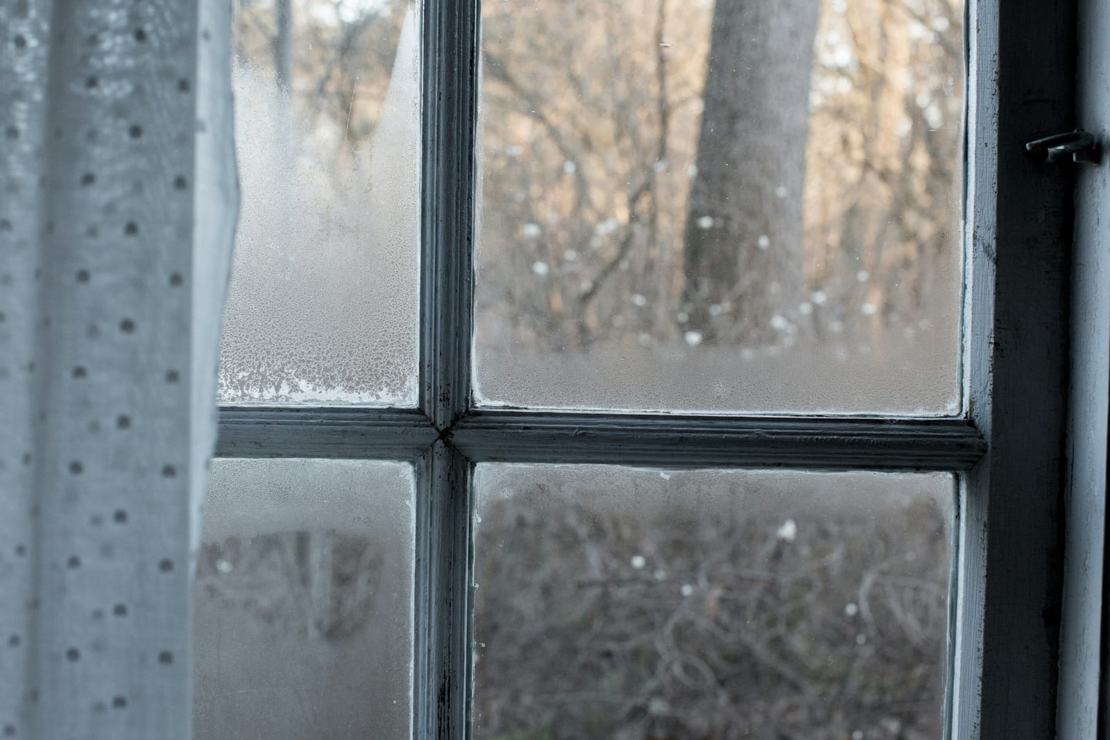 Вікно з легкою фіранкою взимку — штори допомагають утримати тепло